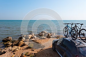 Two bikes on the roof rack of a car against a beautiful nature.