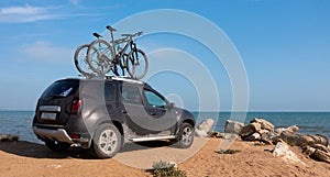 Two bikes on the roof rack of a car against a beautiful nature.