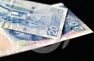 Two bills of twenty Hong Kong dollars on a dark background