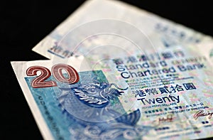 Two bills of twenty Hong Kong dollars on a dark background