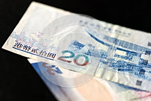 Two bills of twenty Hong Kong dollars on a dark background