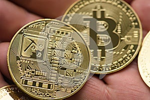 Two bitcoin coins in hand close up