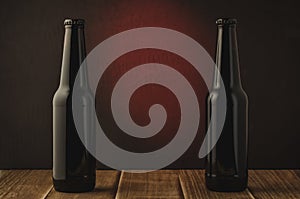 two black bottle of beer on a red background of a wooden shelf/two black bottle of beer on a red background of a wooden shelf. Se