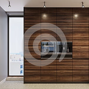 Two black, built-in ovens in wooden kitchen furniture