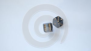 Two black dice roll a pair of fives on white table in slow motion