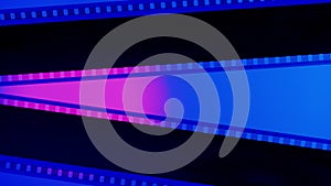 Two black film strips on blue background illuminated with pink neon light, close up. Copy space.