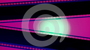 Two black film strips on pink background illuminated with white circular light, close up. Copy space.