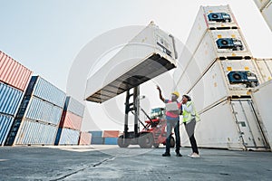 Two Black foreman man & woman worker working checking at Container cargo harbor holding laptop computer and using walkie-talkie to