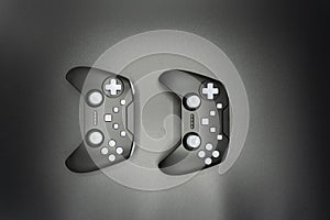 Two black game joysticks with white buttons isolated on gray background