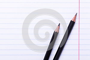 Two black graphite pencils on white sheet in line Copy space Back to school, education concept