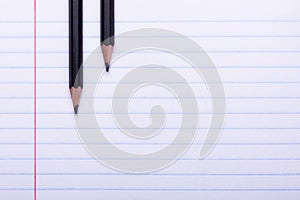 Two black graphite pencils on white sheet in line Copy space Back to school, education concept