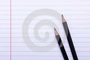 Two black graphite pencils on white sheet in line Copy space Back to school, education concept