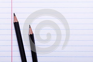 Two black graphite pencils on white sheet in line Copy space Back to school, education concept