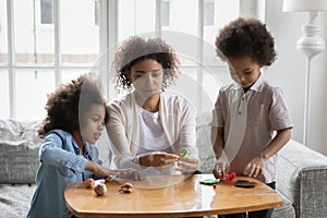 Two black kids and mom sculpting from plasticine at home