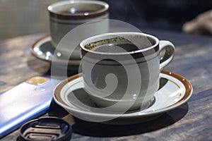 two black koo with saucer on the table