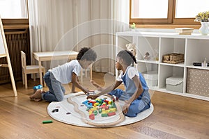 Two Black little sibling children sitting on floor at home