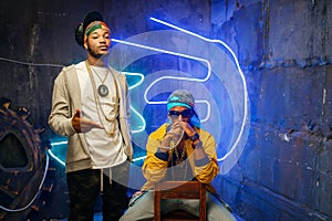Two black rappers, neon lights on background