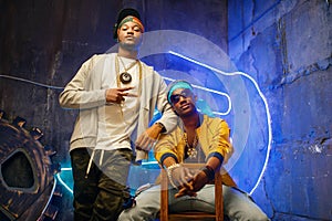 Two black rappers, neon lights on background