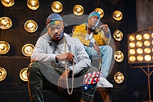 Two black rappers sitting on the steps