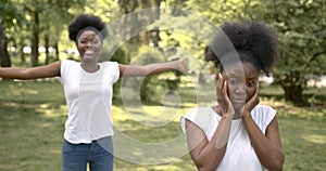 Two black sisters look happy and unhappy