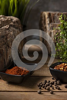 Two black small bowls with dry chillies and sweet paprika