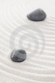 Two black stones in sand, spa or zen concept