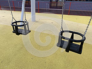 Two black toddlers swings taken at an outdoor play area