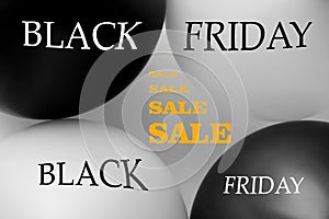 Two black and two white balls with the words Black Friday and the inscription Sale