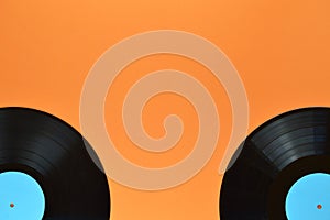 Two black vinyl record on orange background