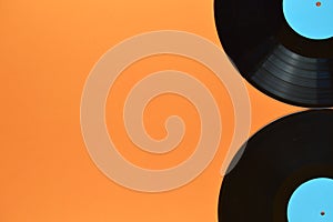 Two black vinyl record on orange background