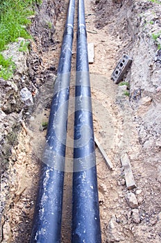 Two black waterpipes in a ditch