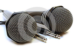 Two black wired karaoke microphones.