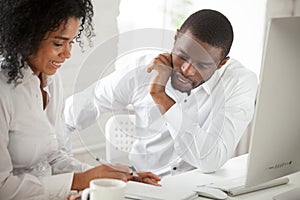 Two black workers discussing business ideas in office
