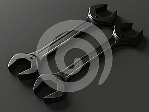 Two black wrenches on a gray surface