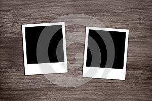 Two blackened instant photo print templates on wooden background photo