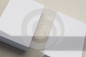 two blank business card stacks, poster, letterheads on brown background with shadow overlay as template for design presentation,