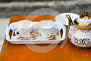 Two blank cup on a tray with a kettle.