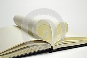 Two blank diary pages that becomes one heart shape. Clean photo of notebook on white background, as concept for valentines day,
