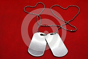 Two blank dog tags on red background