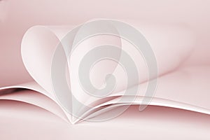 Two blank magazine pages that becomes one heart shape. Clean photo of magazine on pink background, as concept for valentines day,
