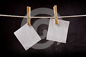 Two Blank paper notes hanging on rope with clothes pins