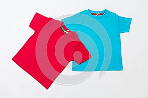 Two blank tshirts on a white background. Red and blue kids t-shirts photo