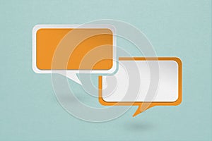blank white and orange speech bubble paper cut ,  on grunge blue paper background. Conceptual image about communication and