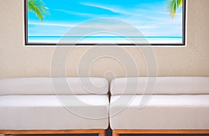 Two blank white sofas near beige roughness concrete wall with sea view inside of glass window frame in modern living room