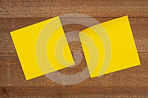 Two blank yellow sticky note on weathered wood