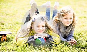 Two blonde girl lie on grass in spring