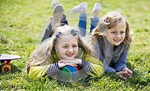 two blonde girl lie on grass in spring