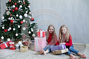 Two blonde girlfriends sisters girls Christmas presents new year tree