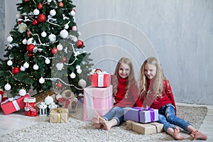 Two blonde girlfriends sisters girls Christmas presents new year tree