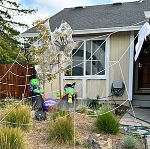 Two blowup witches are in front of a house